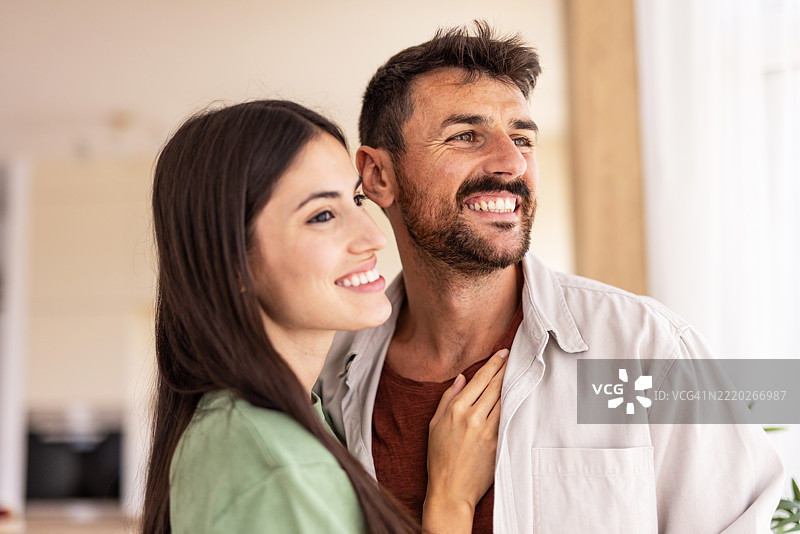 快乐的情侣微笑着，望向新家。图片素材