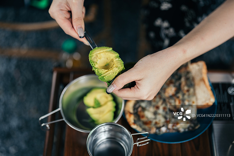露营早晨，一名女性正在准备早餐的特写镜头图片素材