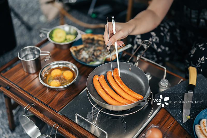 露营早晨，一名女性正在准备早餐的特写镜头图片素材