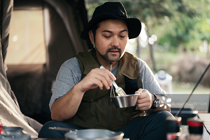 一个男人在早晨露营时准备早餐图片素材