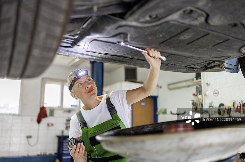 女性机械师使用抽油器更换汽车机油图片素材
