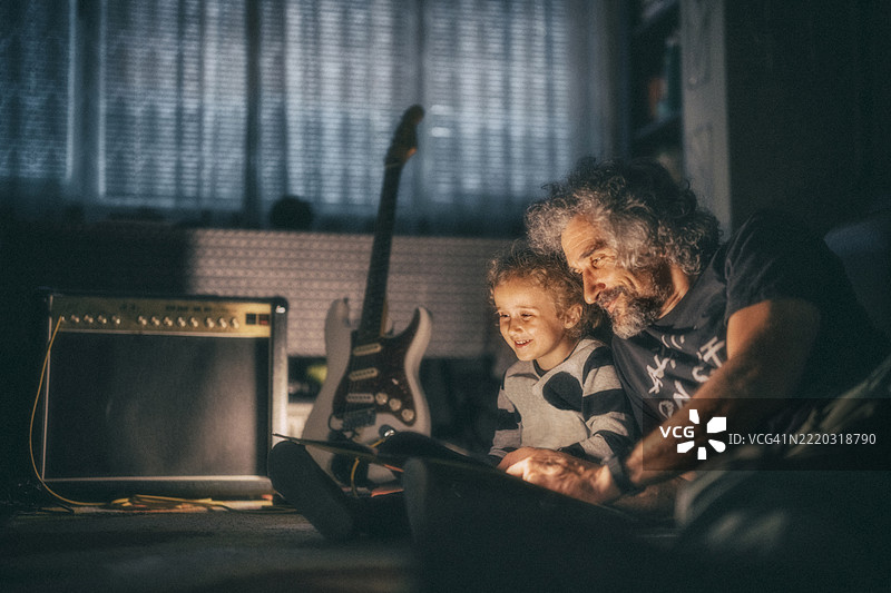 睡前故事与爸爸。父亲和孩子在深夜阅读书籍。图片素材