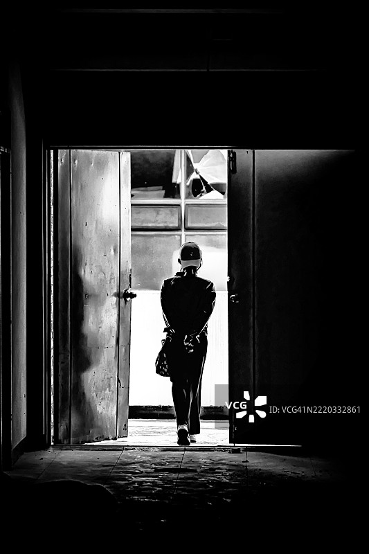 一位女士走过破旧的门口图片素材