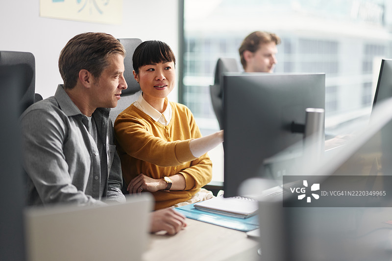 商务同事在办公室的桌面电脑上阅读代码。图片素材