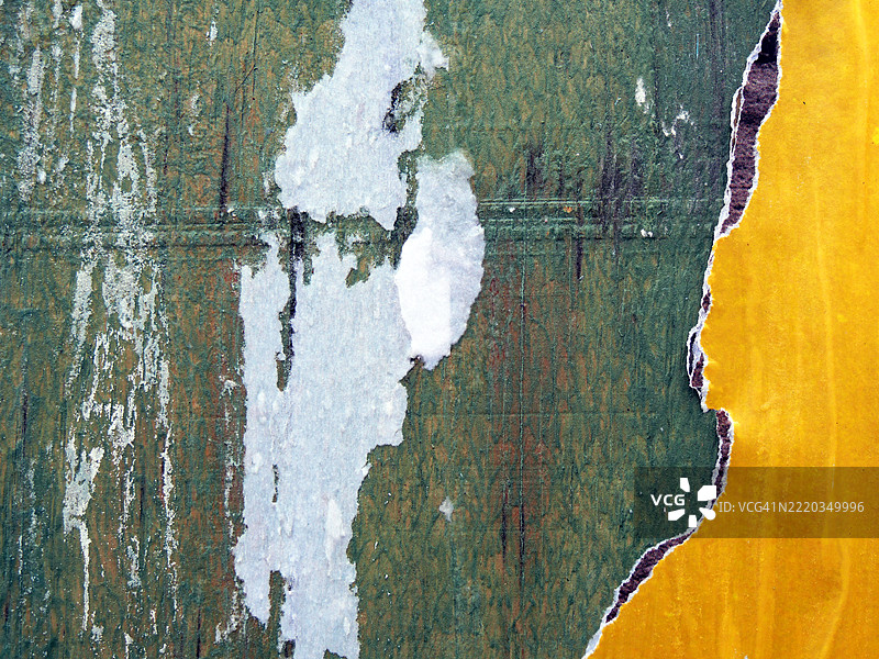 撕毁的黄色和黑色海报贴在涂有绿色油漆的木板上，白纸被刮掉。粗糙的质感。阳光。自然色彩和铜绿。全画幅 4:3。美国纽约州曼哈顿。图片素材