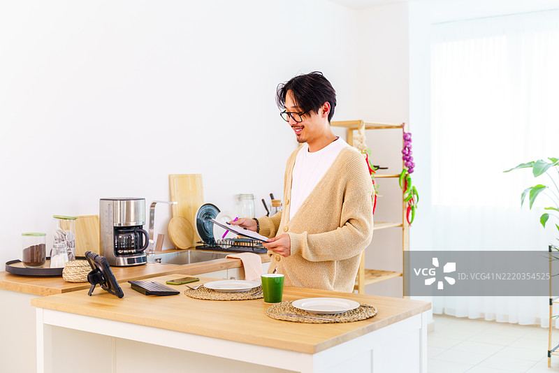 在家远程工作，视频通话，男人与笔记本电脑，互联网连接或会议通话。男性，企业家或演讲者在厨房进行对话或网络研讨会。图片素材