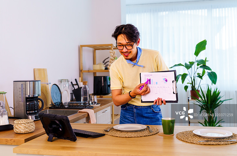 在家远程工作，视频通话，男子与笔记本电脑，互联网连接或会议通话。男性，企业家或演讲者在厨房进行对话或网络研讨会。图片素材