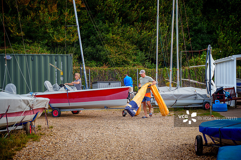 老年男性和老年女性正在为帆船比赛准备他的船只图片素材