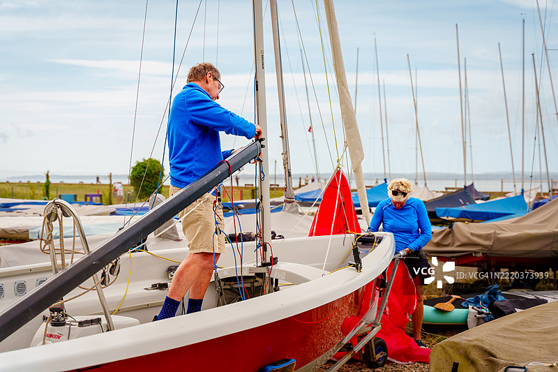 老年夫妇为帆船比赛准备他们的船只图片素材
