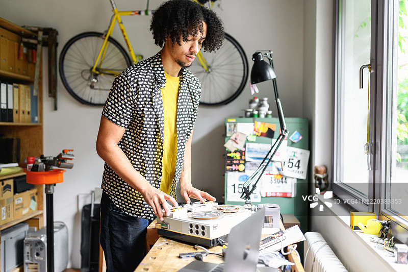 年轻男子在查看复古的卷带录音机图片素材