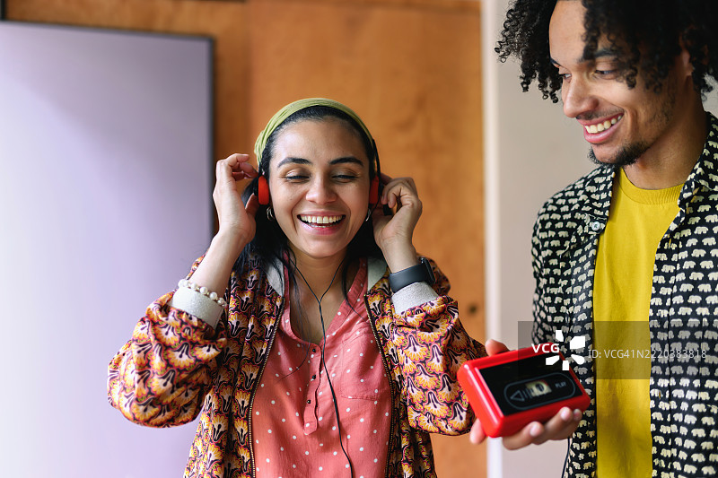 年轻的微笑男女一起用复古随身听听音乐图片素材
