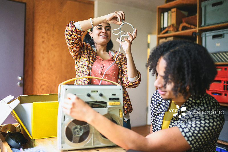年轻男女在查看复古的卷带录音机图片素材