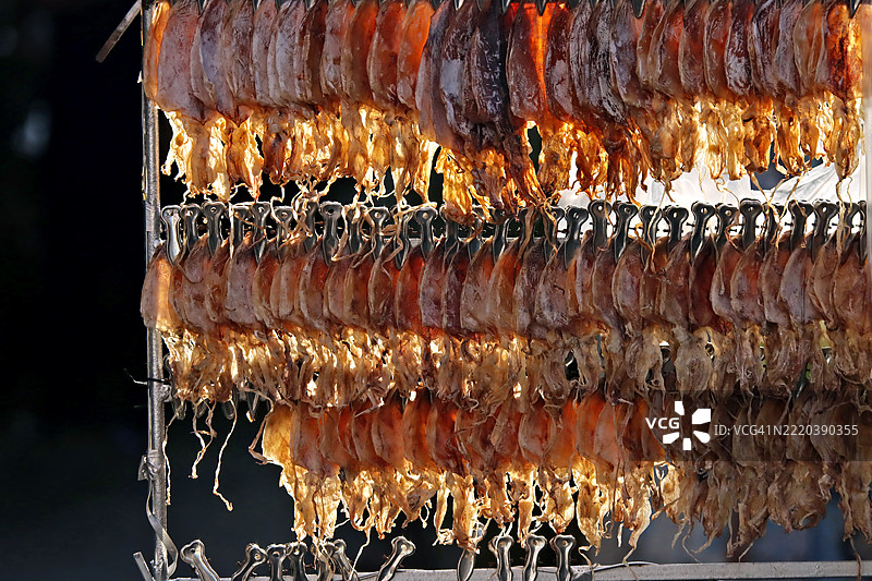 街头市场上悬挂的干鱿鱼，正在出售图片素材