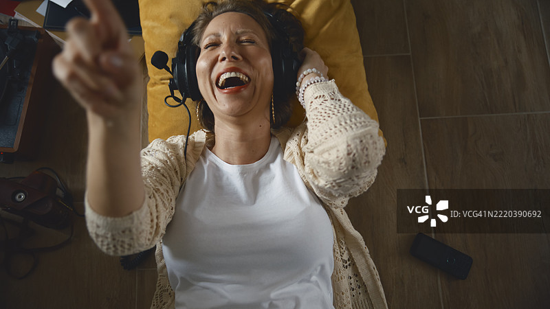 快乐的女性在室内放松，佩戴复古耳机听音乐图片素材