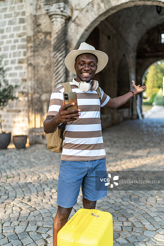 年轻的黑人游客在古老建筑前进行视频通话图片素材