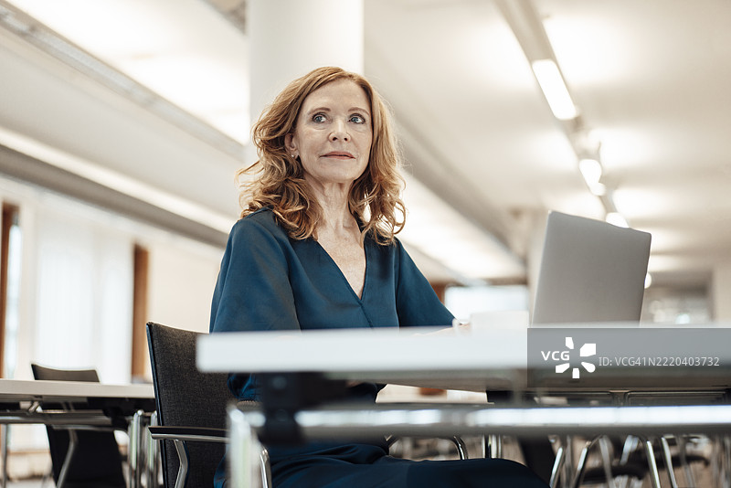 资深女商人在办公室工作时侧目而视图片素材