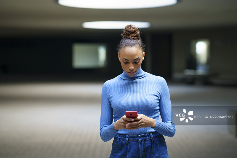 女性在停车场内站着使用智能手机图片素材
