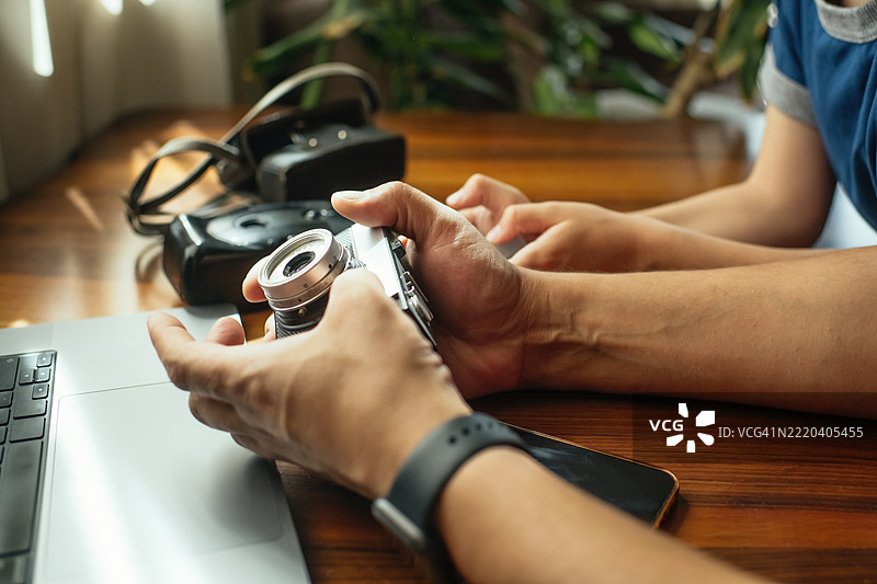 父亲向儿子展示一台老式复古相机图片素材