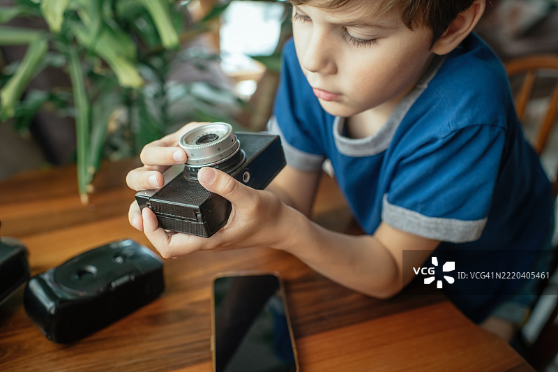 在家里拿着复古相机的孩子图片素材