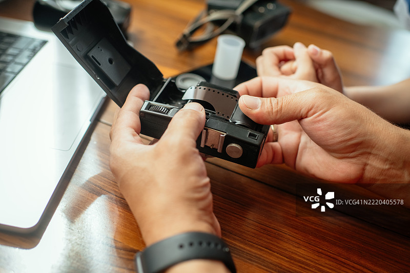 父亲向儿子展示一台老式复古相机图片素材