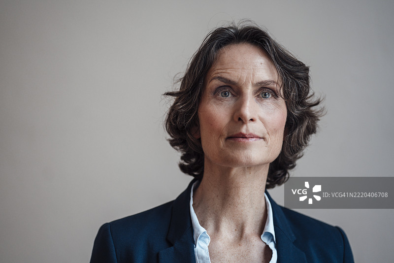 成熟的女商人在白色墙壁前图片素材