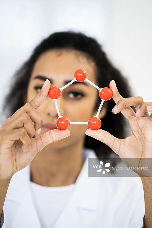 年轻研究人员在实验室中握着DNA分子结构图片素材