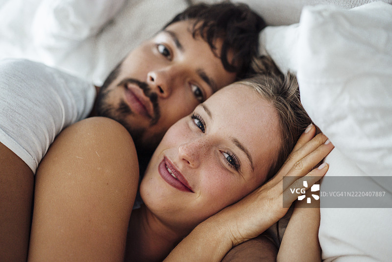 美丽的女人与男朋友躺在床上图片素材