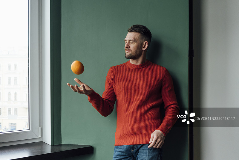 商人在墙前玩橙子图片素材