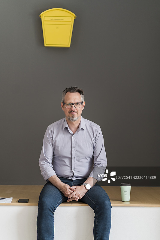 商人在办公室墙上的邮筒前坐着图片素材