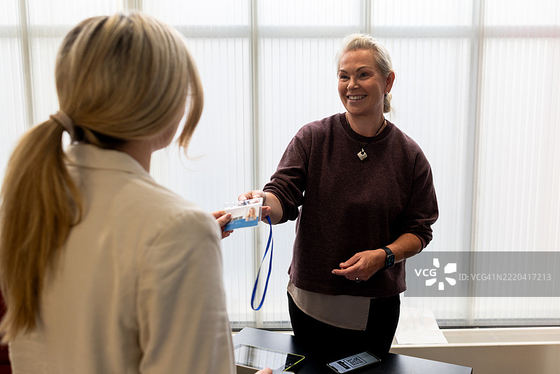 女商人在会议签到处领取名牌图片素材