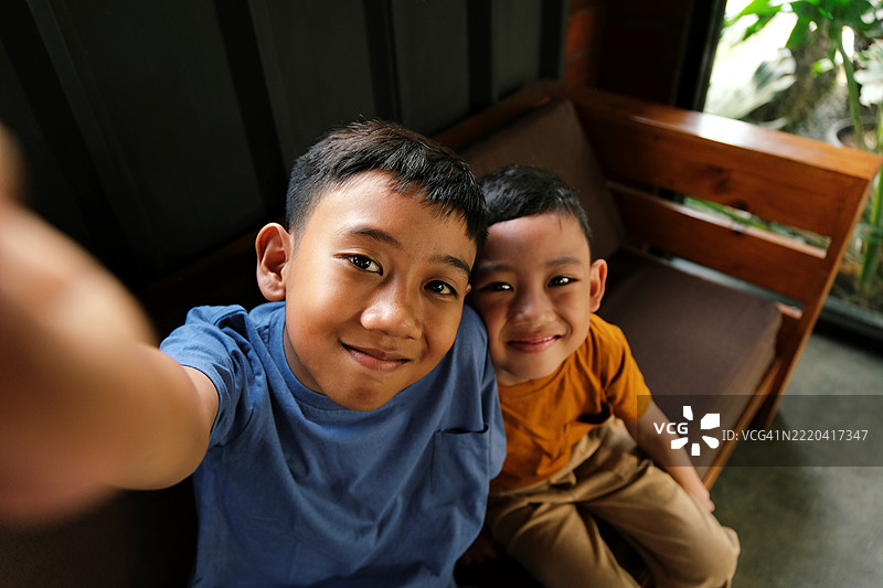 快乐的兄弟姐妹在室内一起自拍图片素材