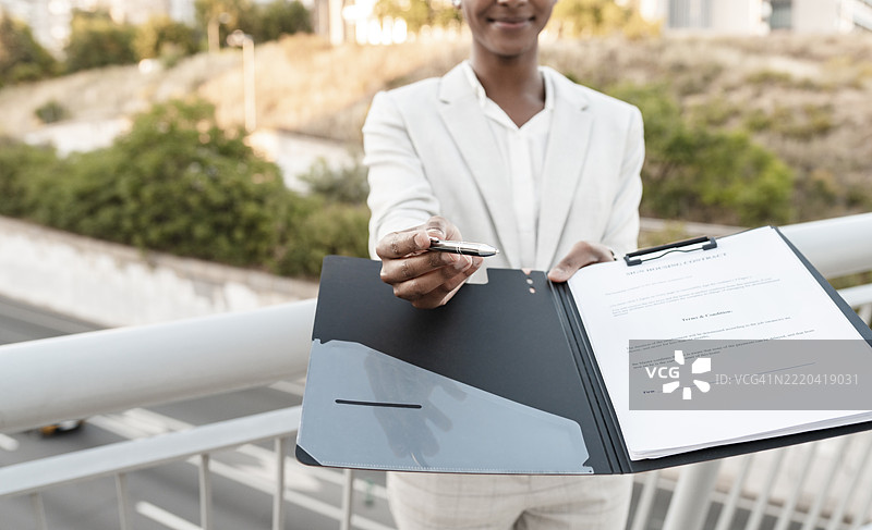 女销售员在桥上展示合同文件图片素材