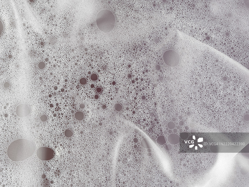 米色调的丝绸布料上混合着浮雕泡沫和肥皂泡。图片素材
