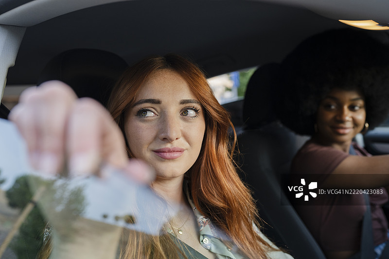 女性朋友坐在车里透过窗户观看图片素材