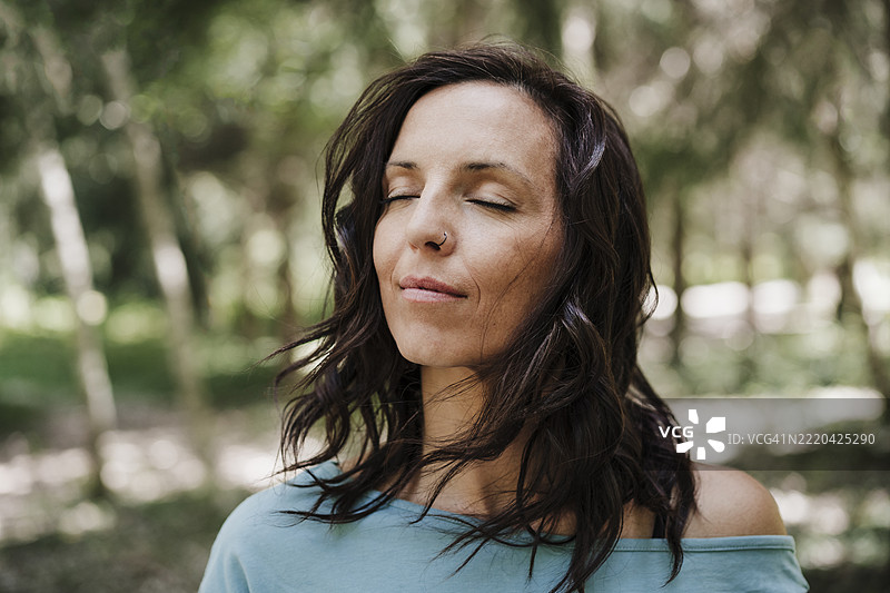 中年女性在森林中闭眼图片素材