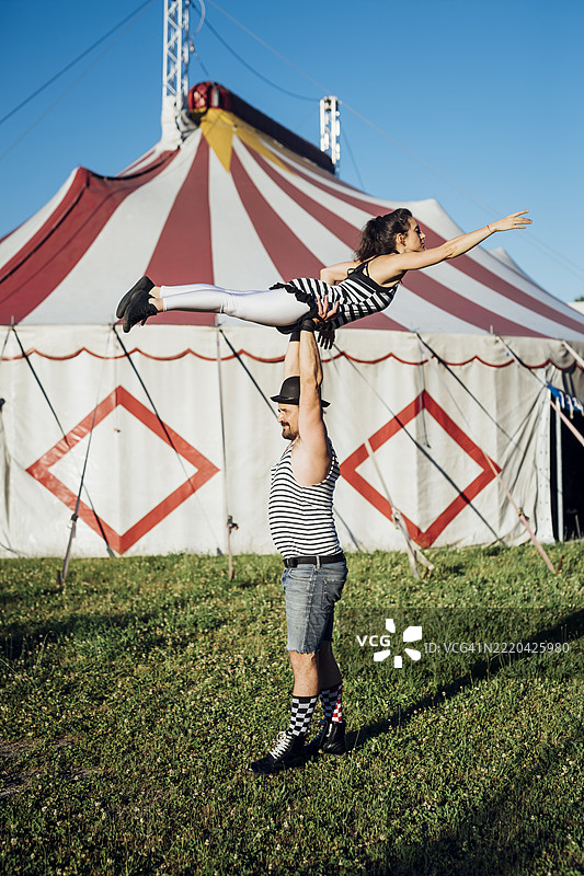 男女杂技演员在草地上共同表演图片素材