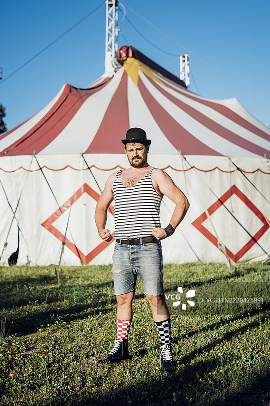 肌肉发达的艺术家在马戏团帐篷前展示肌肉图片素材