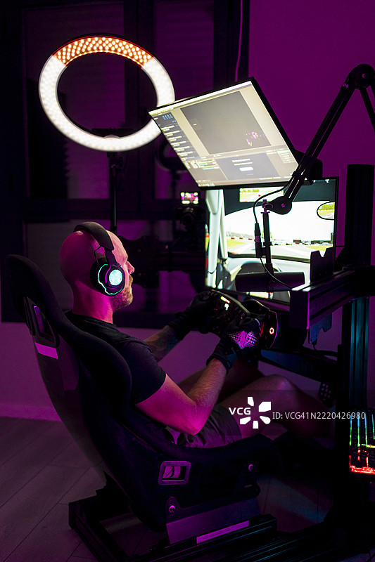 戴着耳机的男性玩家在工作室里玩视频游戏图片素材