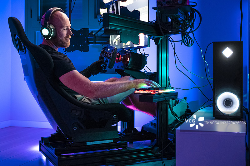 男性玩家在工作室里玩电脑游戏图片素材