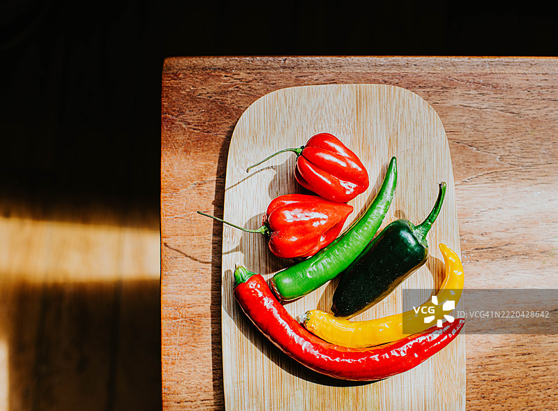 从上方拍摄的各种辣椒在切菜板上的图像图片素材
