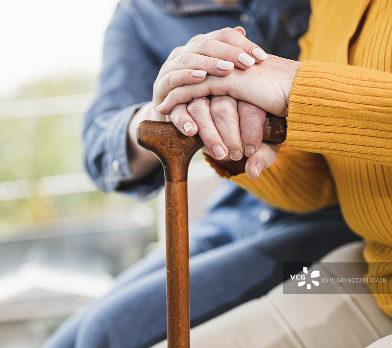 在家中，女性双手叠放在手杖上图片素材