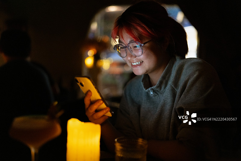 女人在烛光桌旁使用智能手机图片素材