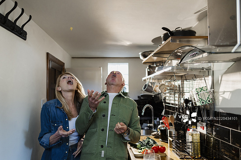 老年夫妇在家厨房里愉快地唱歌并吃麦片图片素材