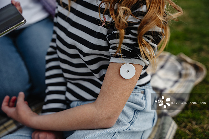 母女在公园使用血糖监测仪图片素材