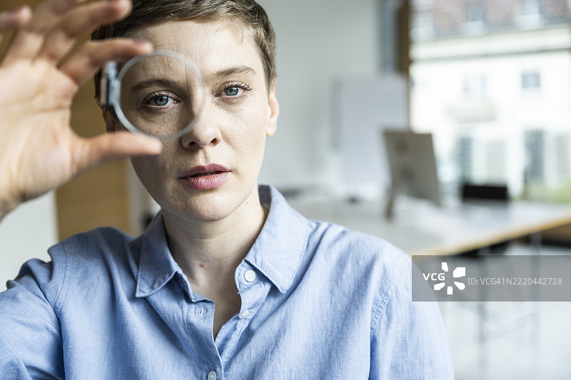 女性在办公室分析机械部件，专注于工程领域图片素材