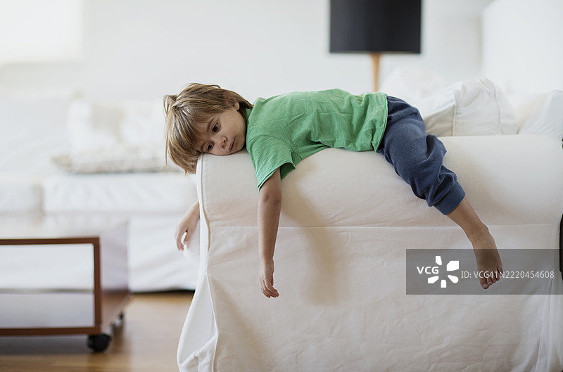 孩子在阳光明媚的舒适客厅沙发上放松。图片素材