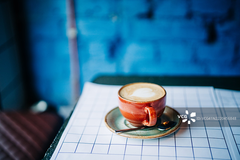 新鲜冲泡的拿铁咖啡放在桌子上。图片素材