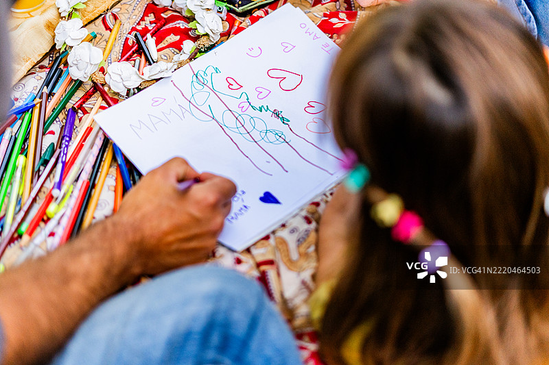 父亲和女儿在家准备母亲节卡片的特写镜头图片素材