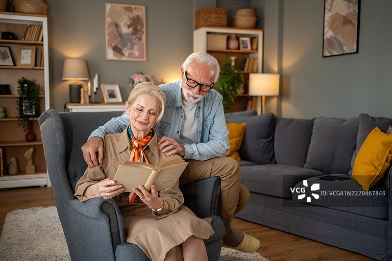 老年夫妇在家中一起阅读书籍，享受美好时光图片素材