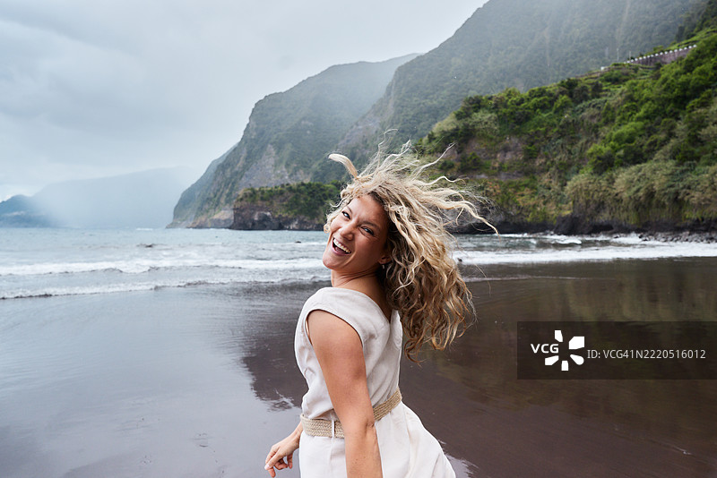 快乐的女人在海滩上玩得很开心。图片素材